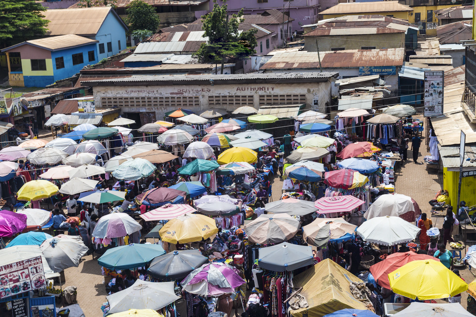 Parasols colorés au-dessus d'un marché animé à Obuasi