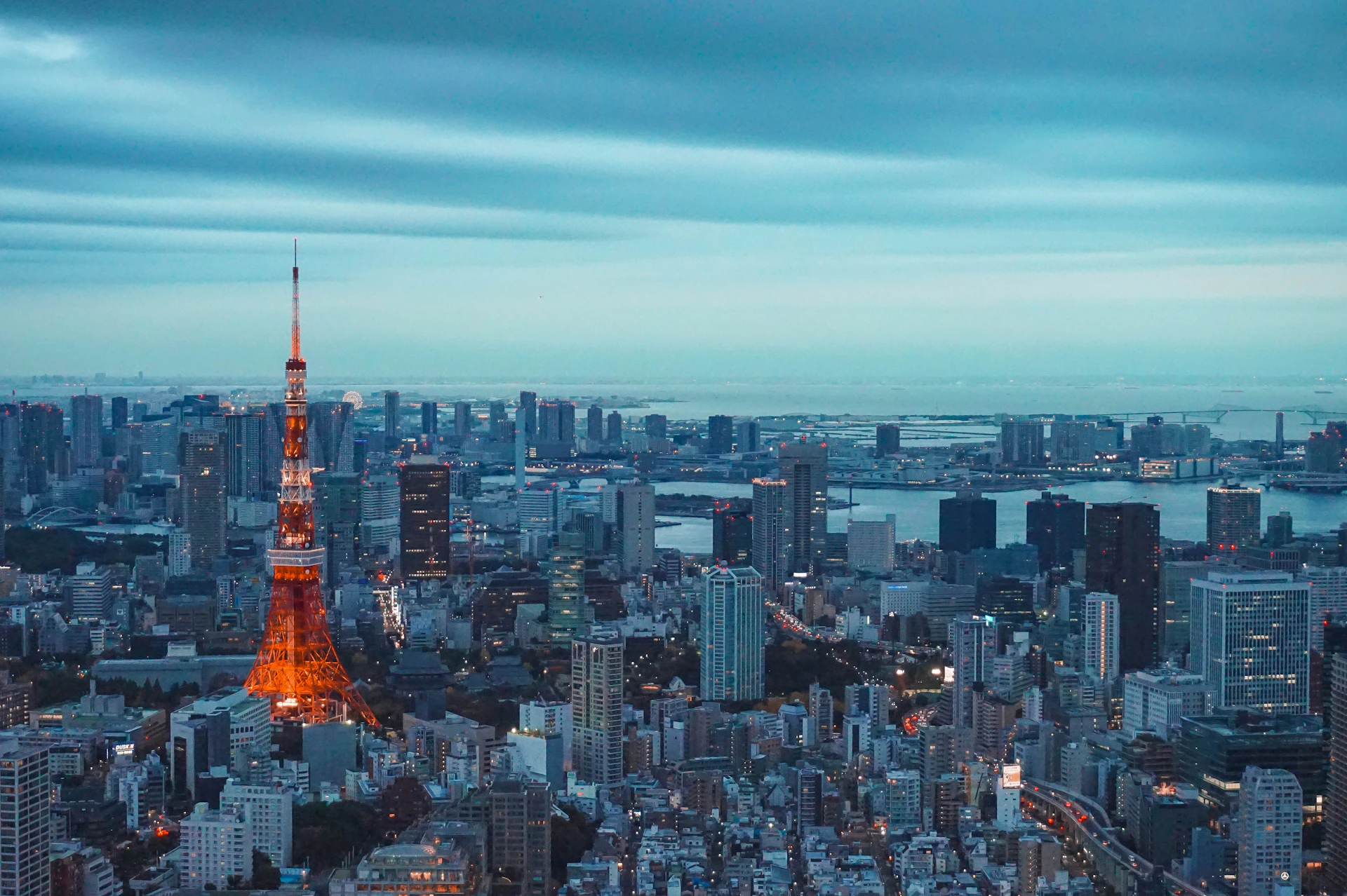 La tour de Tokyo illuminée au crépuscule au-dessus des toits de Tokyo et de la baie