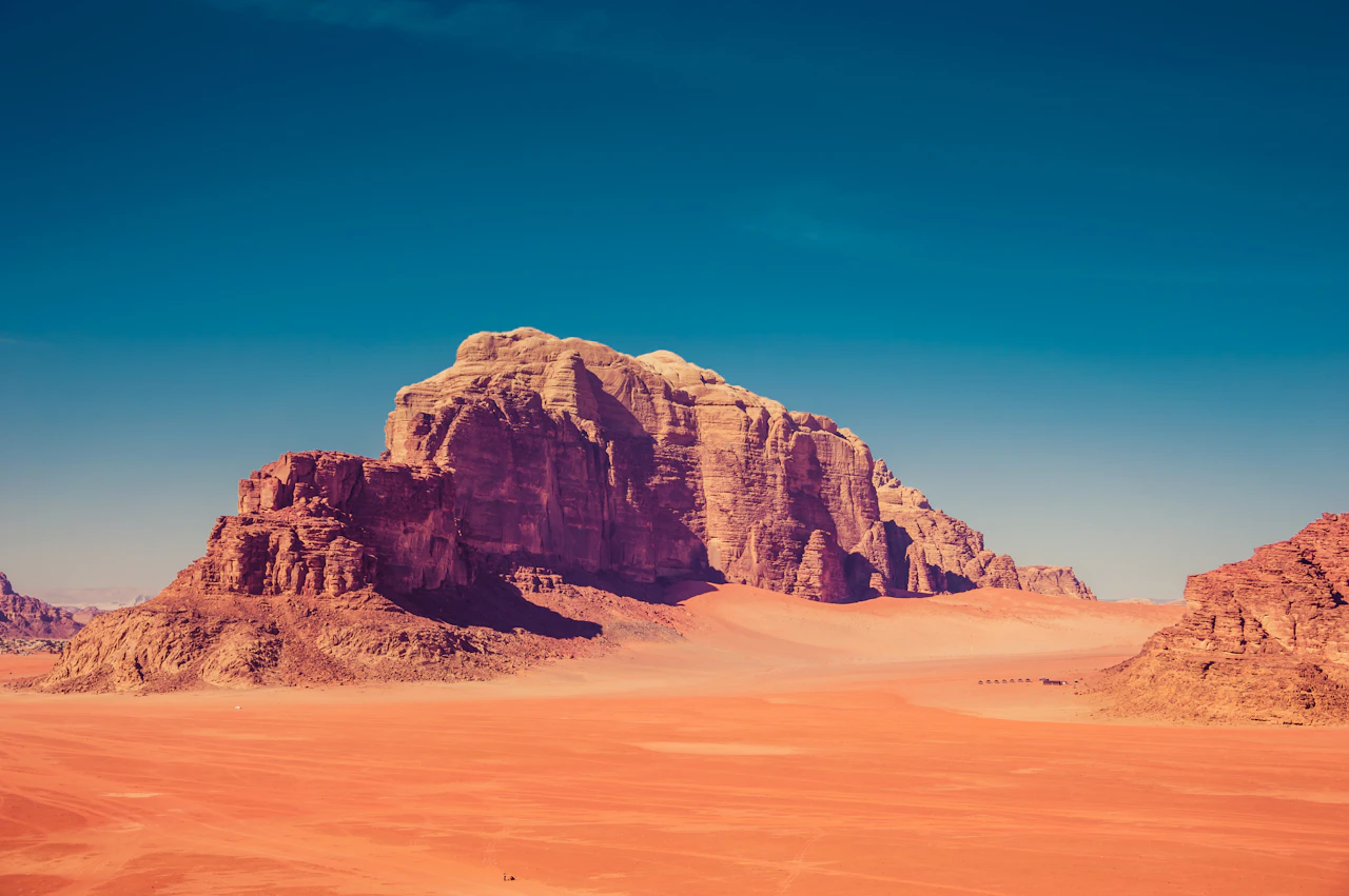 Montagne di arenaria rossa che si alzano dal deserto del Wadi Rum