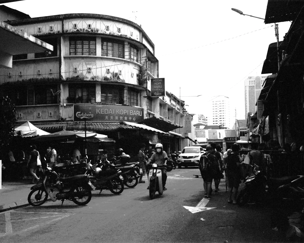 Un triciclo aparcado junto a macetas en una calle de Penang