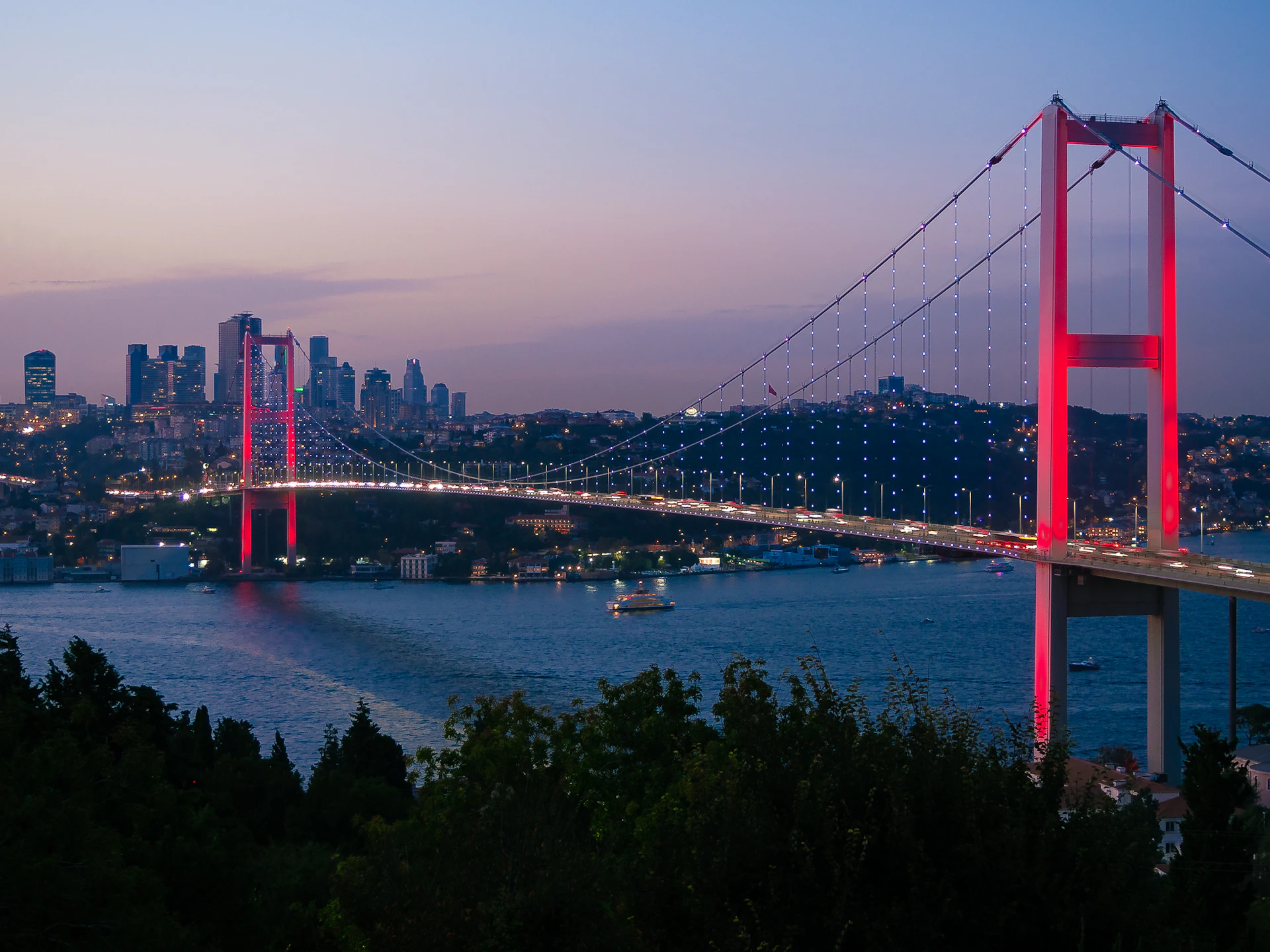 Il ponte sul Bosforo illuminato al crepuscolo sopra Istanbul