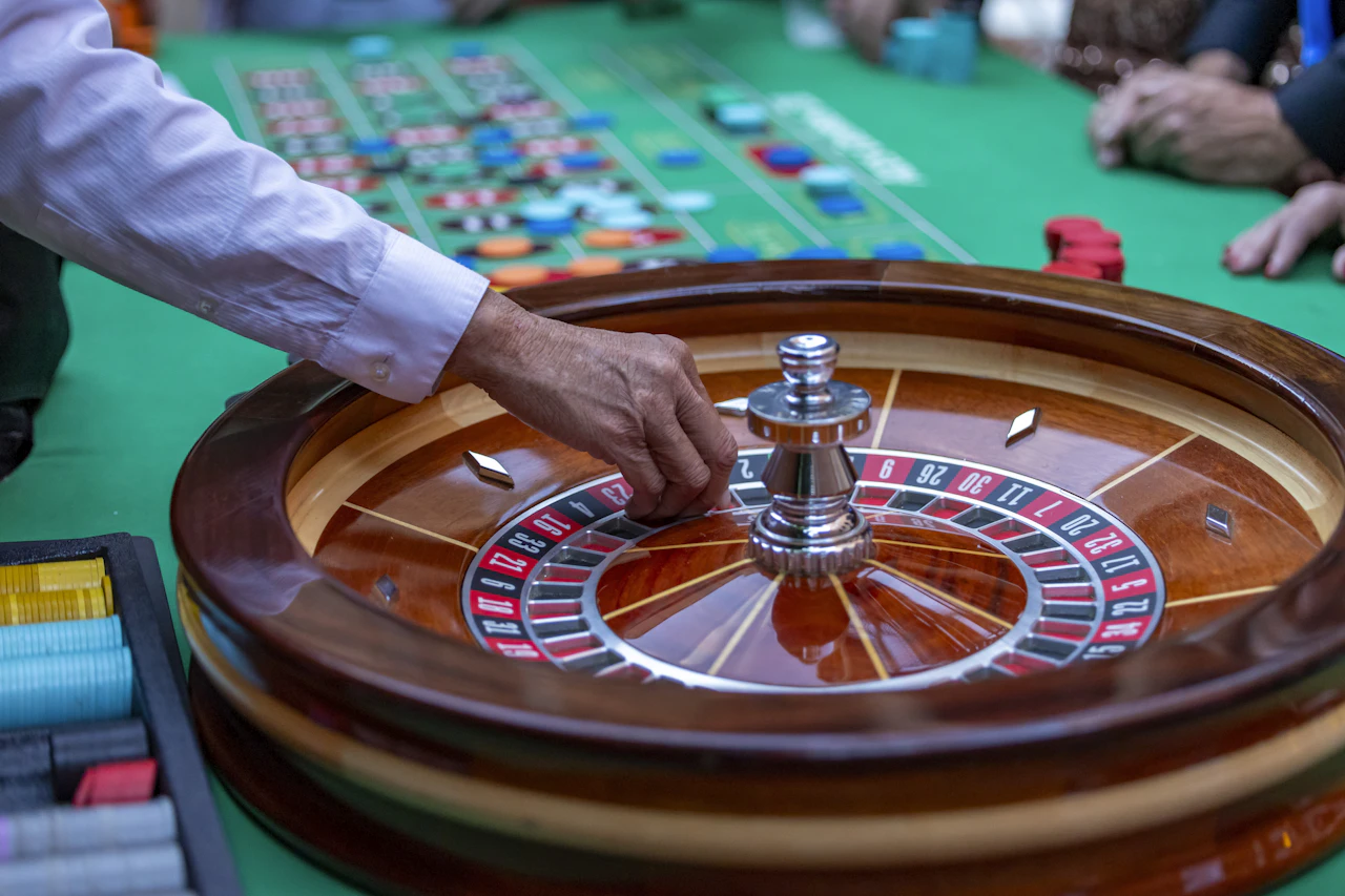 A dealer spinning a roulette wheel at a casino table