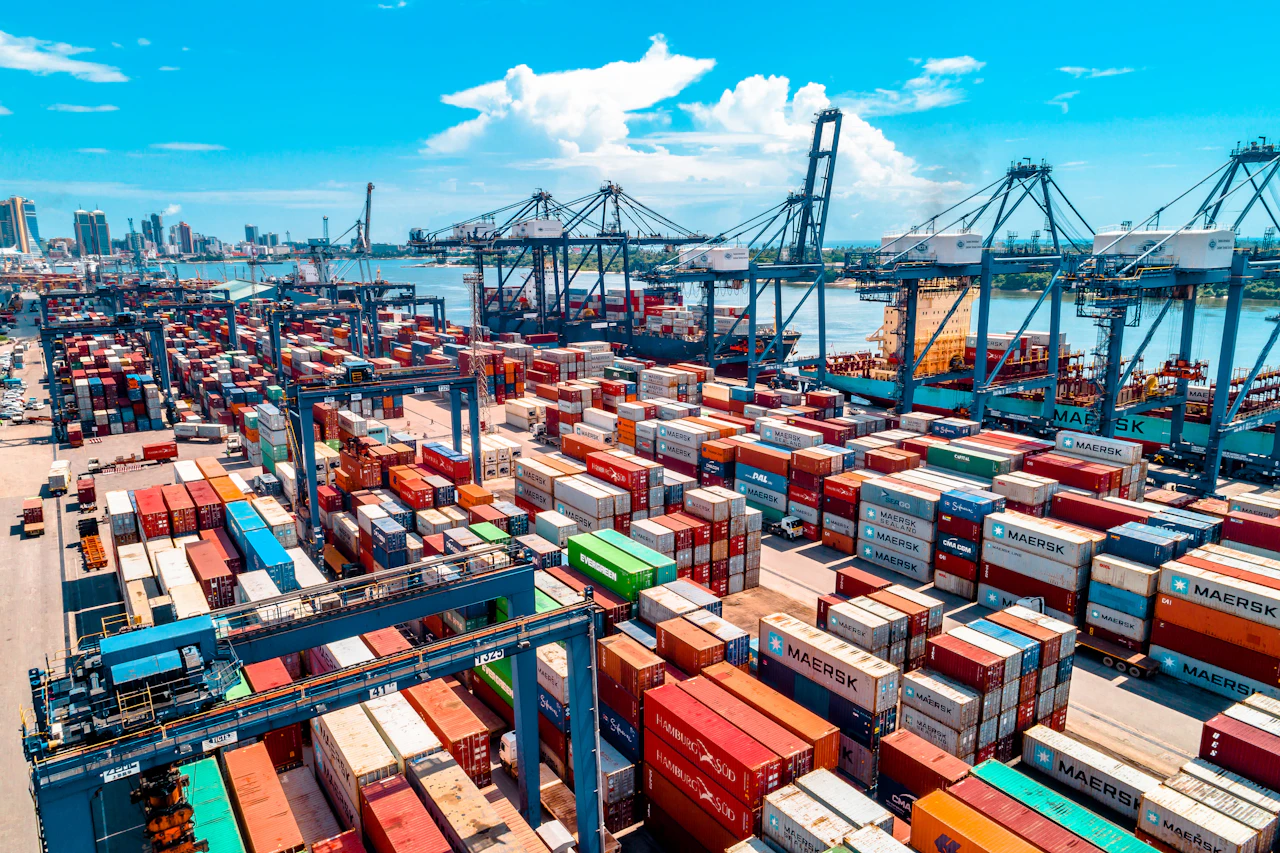 An aerial view of stacked shipping containers at a busy port