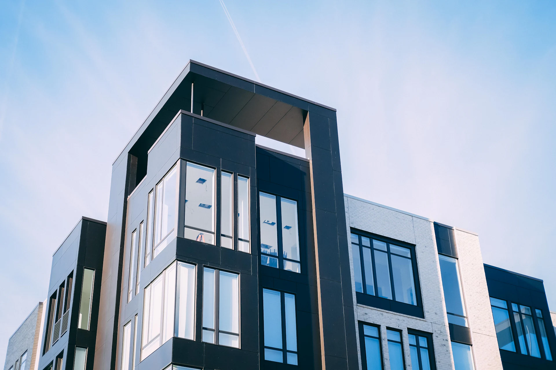 A modern apartment building seen from below against the sky