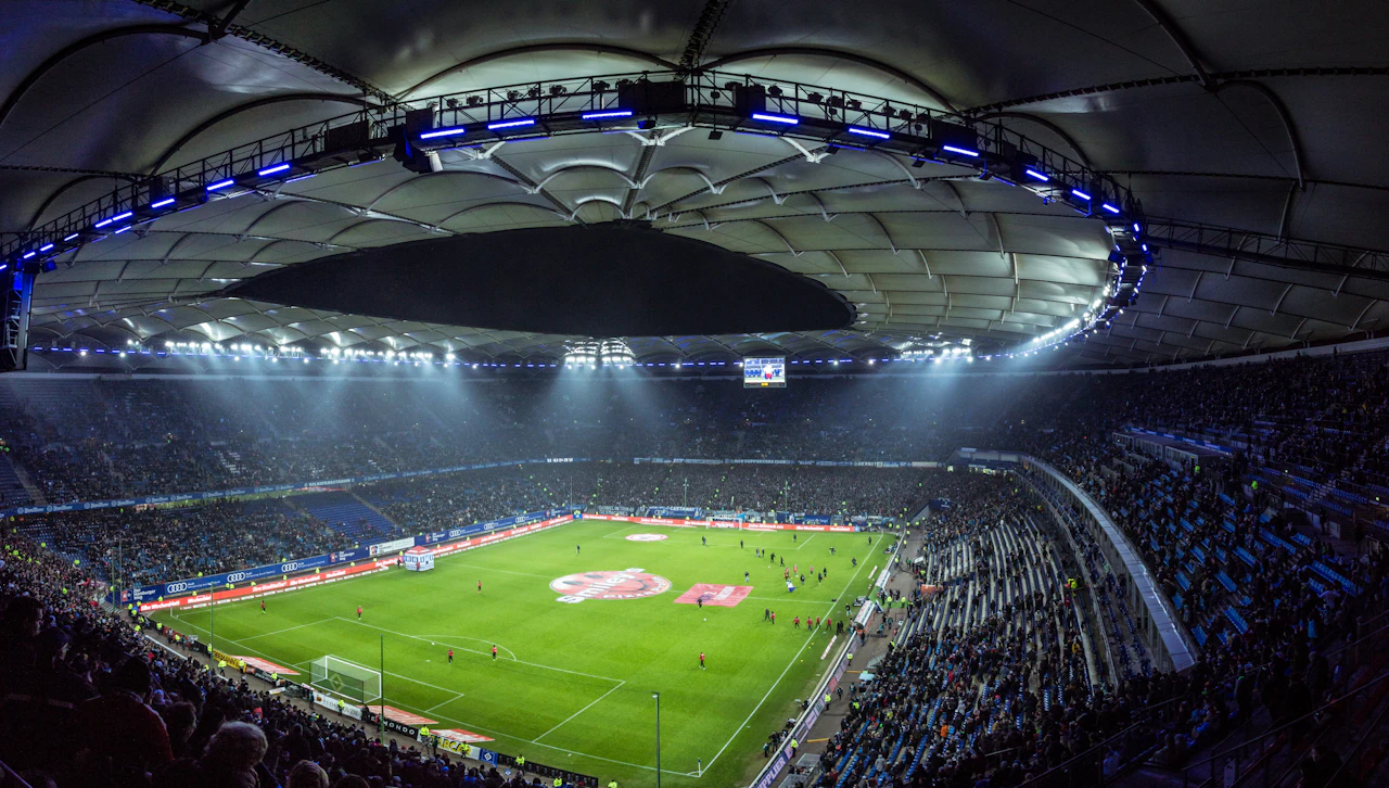 A floodlit football stadium seen from high in the stands